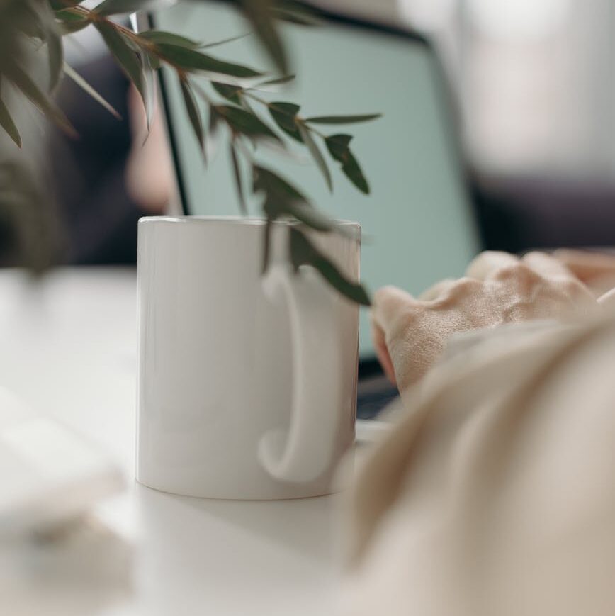 white ceramic mug on white table